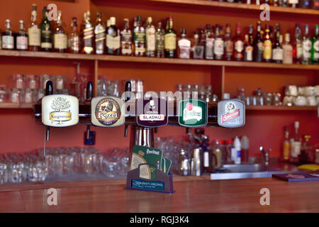 Rubinetti di birra nel bar di Praga con i bicchieri e bottiglie di spirito in background Foto Stock