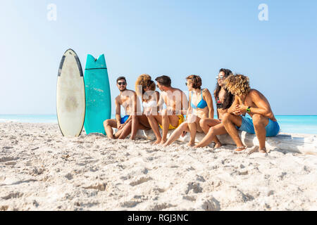 Giovani surfisti prendendo una pausa, seduto sulla spiaggia Foto Stock