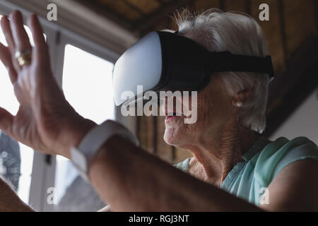 Senior donna utilizzando la realtà virtuale auricolare Foto Stock