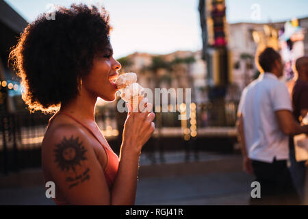 Stati Uniti d'America, Nevada, Las Vegas, felice giovane donna a mangiare il gelato in città Foto Stock