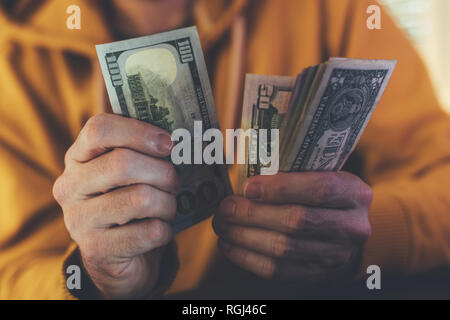 Uomo informale è il conteggio dollaro americano banconote, close up delle mani con il denaro Foto Stock