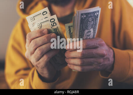 Uomo informale è il conteggio dollaro americano banconote, close up delle mani con il denaro Foto Stock