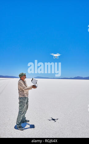 Bolivia, Salar de Uyuni, uomo flying drone sul lago salato Foto Stock