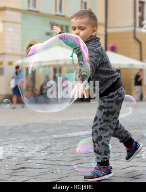 Giovani femmine Busker rendendo bolle per i bambini a giocare con al centro di Wrocław, Polonia Foto Stock