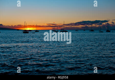Silhouette di barche ormeggiate con il sole che tramonta sullo sfondo. Foto Stock