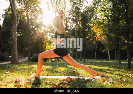 Montare la giovane donna a praticare yoga in un parco Foto Stock