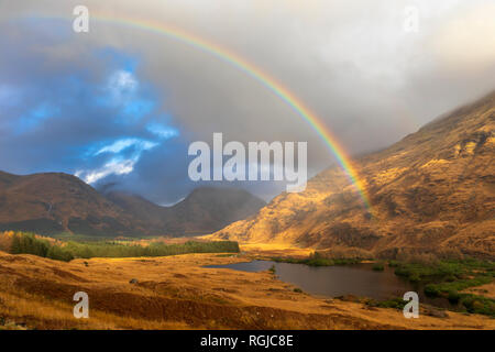 A rainbow over Lochan Urr in Glen Etive in Scotland. Foto Stock