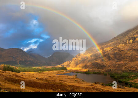 Un arcobaleno su Lochan Urr in Glen Etive in Scozia. Foto Stock