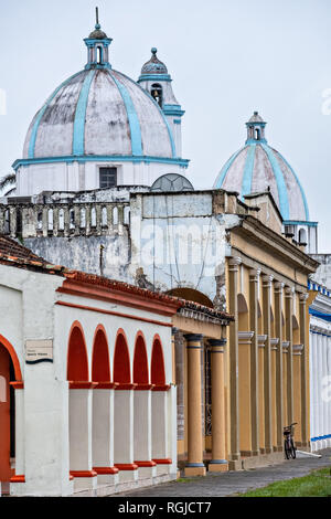 Le cupole del Santuario di Nostra Signora della Candelora chiesa torre sopra il colonnato colorati edifici di stile in Tlacotalpan, Veracruz, Messico. La piccola città è dipinto un tripudio di colori e le caratteristiche ben conservate Caraibi coloniale stile architettonico risalente alla metà del XVI ° secolo. Foto Stock