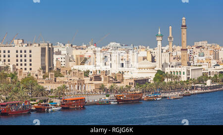 Ristorante tradizionale dhow ormeggiati in Dubai Creek, Dubai, EAU. Il vecchio quartiere mercantile della Bastikiya può essere visto nella rassegna. Foto Stock