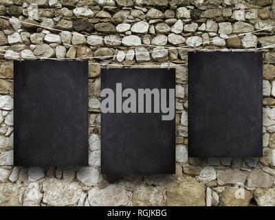 Tre lavagna vuota telai contro il vecchio muro di pietra sullo sfondo Foto Stock