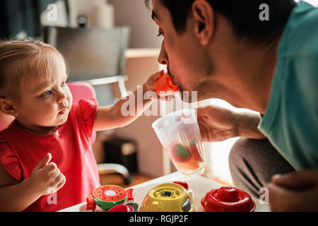 Bambina giocare insieme con suo padre a casa Foto Stock