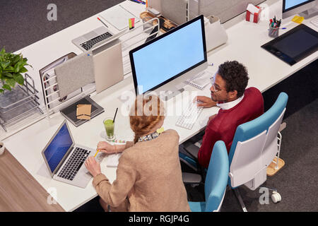 I colleghi che lavorano in ufficio moderno, parlando di progetto Foto Stock