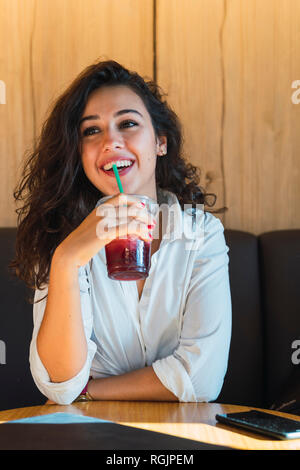 Ritratto di felice giovane donna frullato potabile Foto Stock