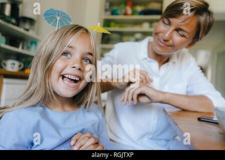 Felice madre e figlia divertirsi a tavola in casa Foto Stock