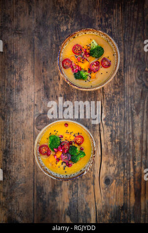 Due ciotole di piatto di curry con zucca Hokkaido, broccoli, pomodori, melograno e semi di sesamo nero Foto Stock