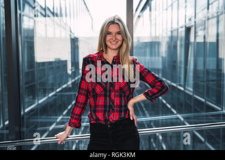 Ritratto di sorridente giovane donna indossa plaid shirt Foto Stock