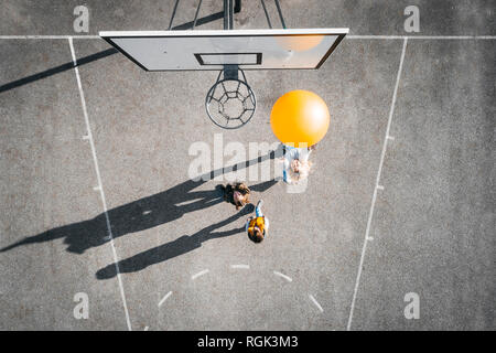 L'Austria, la vista aerea del campo di pallacanestro, madre e bambini giocare a basket con grande palla