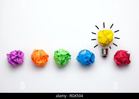 Grande idea concetto accartocciata con carta colorata e la lampadina. Foto Stock