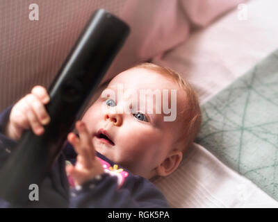 Baby girl holding di controllo remoto Foto Stock