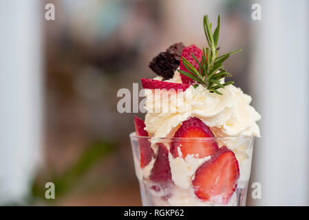 Dolce gelato alla crema con fragole fresche e panna montata Foto Stock