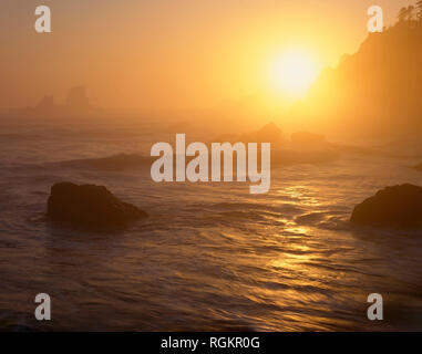 Stati Uniti d'America, Oregon, Ecola State Park, set di Sole attraverso lo strato di nebbia al punto Ecola. Foto Stock