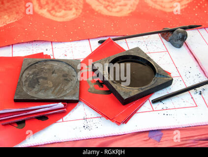 La calligrafia cinese Pennello e inchiostro, carta rossa Foto Stock