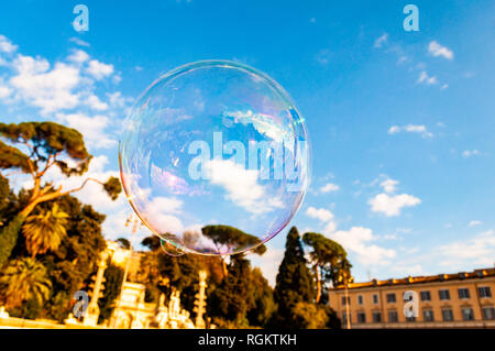 Luce colorata e bolle di sapone a volare con il vento in aria per il cielo sopra la Piazza del Popolo Foto Stock