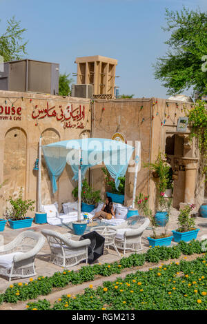 Dubai, UAE / 11. 05. 2018: tradizionale tè casa nella vecchia Dubai in una architettura araba edificio con una ragazza di bere il tè Foto Stock