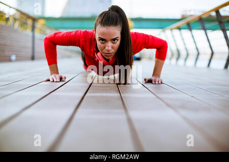 Giovane donna esercita sul lungomare dopo aver eseguito la mattina Foto Stock