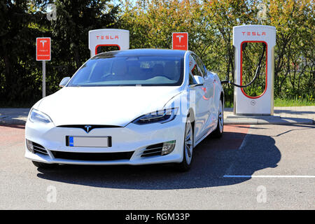 PAIMIO, Finlandia - 3 giugno 2017: Bianco Tesla Model S di lusso auto elettrica è in carica di Tesla Supercharger stazione su una bella giornata d'estate. Foto Stock