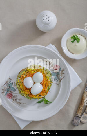 Uova di quaglia in carote nido con frittelle di zucchine Foto Stock