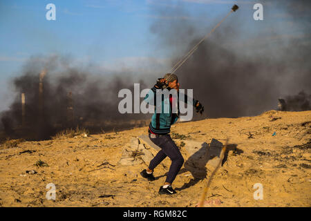 Gennaio 29, 2019 - Striscia di Gaza, 29 gennaio 2019. Un certo numero di palestinesi sono stati feriti durante una dimostrazione sulla riva vicino a Beit Lahia, nel nord della Striscia di Gaza, mentre alcuni hanno preso il via in piccole barche da pesca battenti bandiere palestinese nel Mare Mediterraneo, nel corso di una protesta settimanale contro il popolo israeliano blocco navale. Alcuni palestinesi scagliate pietre verso il recinto a forze israeliane, che stavano sparando proiettili e gas lacrimogeni a manifestanti ferendo un certo numero di essi. Giornalisti che coprono la dimostrazione sono stati colpiti anche dal gas lacrimogeni. L'esercito israeliano palestinese permette f Foto Stock