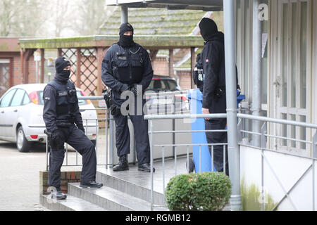 Meldorf, Germania. 30 gen, 2019. Le forze di polizia sono in piedi di fronte a una casa. Il Mercoledì mattina, gli ufficiali della Polizia giudiziaria federale Ufficio arrestati tre uomini dall'Iraq nel distretto di Dithmarschen in Schleswig-Holstein che hanno detto di aver pianificato un attentato terroristico in Germania. Credito: Bodo segna/dpa/Alamy Live News Foto Stock