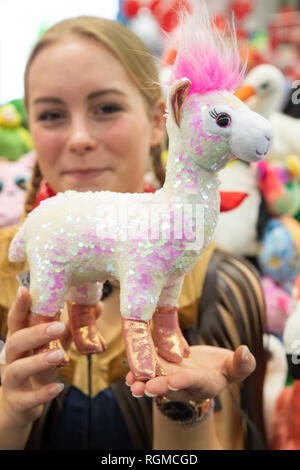 Nurmberg, Germania. 30 gen, 2019. Lara è in possesso di un alpaca animale di peluche con paillettes reversibile nelle sue mani presso la società tedesca Heinrich Bauer stand alla fiera del giocattolo 2019. Il più grande del mondo di Toy Fair avrà luogo quest'anno dal 30 gennaio al 3 febbraio 2019. Foto: Daniel Karmann/dpa Credito: dpa picture alliance/Alamy Live News Foto Stock