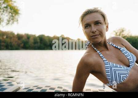 Ritratto di donna che indossa un bikini in un lago Foto Stock