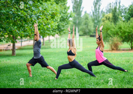 I giovani che esercitano lo yoga in un parco Foto Stock