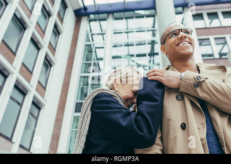 Felice donna matura e giovane uomo sorridente Foto Stock