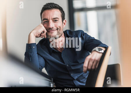 Coppia uomo seduto in ufficio, pensando, testa pendente a portata di mano Foto Stock