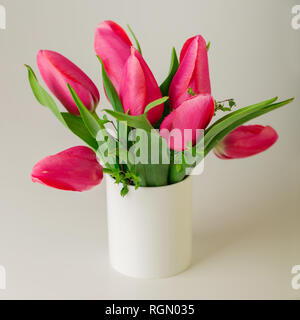 La molla bouquet di tulipani rosa con rami di un albero di fioritura di una luce sullo sfondo di legno. Messa a fuoco selettiva. Foto Stock