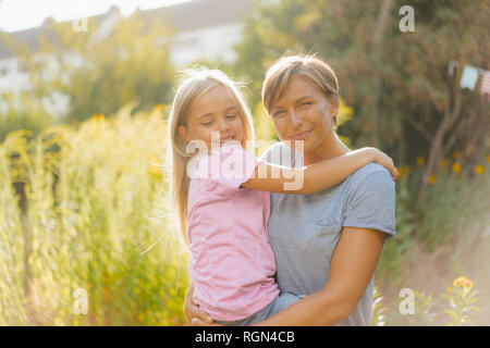 Ritratto di Madre sorridente portando la figlia in natura Foto Stock