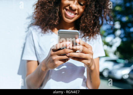 Le mani della giovane donna tenendo lo smartphone, close-up Foto Stock