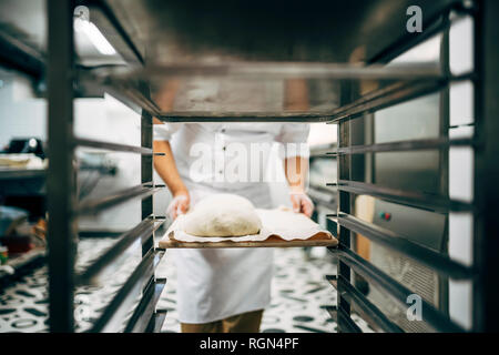 Baker lavoro vassoio di preparazione a fare il pane Foto Stock