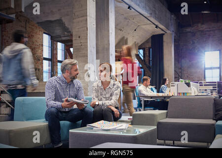 La gente di affari avente una riunione informale nella fossa di comunicazioni Foto Stock