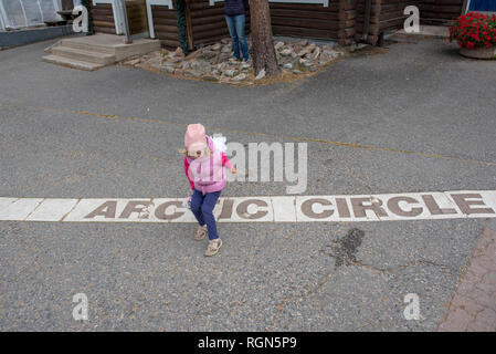 Finlandia, Rovaniemi, ragazza attraversando il Circolo Polare Artico Foto Stock