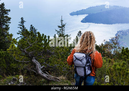 Giovane donna escursioni nelle montagne bavaresi, guardando il Lago Walchensee Foto Stock