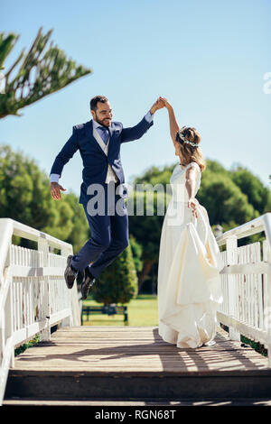 Coppia di sposi godendo il loro giorno di nozze in un parco Foto Stock
