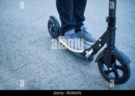 L'uomo con i piedi sul scooter Foto Stock