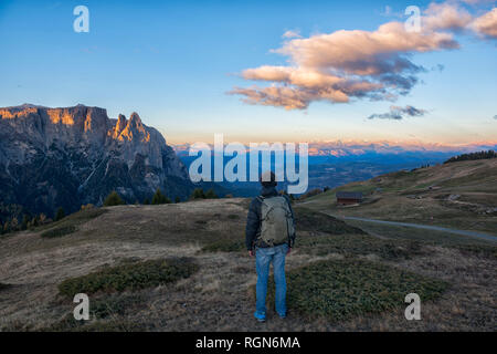 L'Italia, Trentino, Alpe di Siusi, escursionista nella parte anteriore dello Sciliar presso sunrise Foto Stock