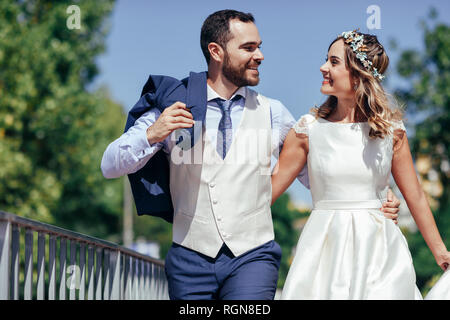 Felice coppia di sposi godendo il loro giorno di nozze in un parco Foto Stock